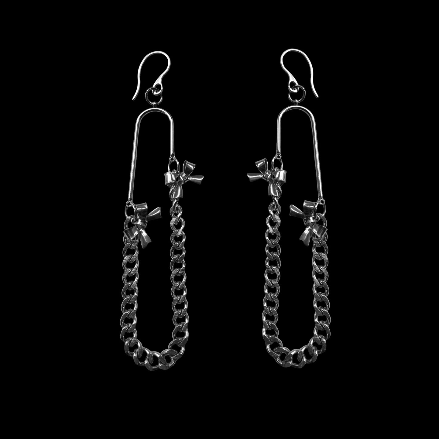 Pair of silver chain earrings on a black background